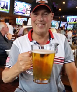 Cliff van Leeuwen zittend met een glas in zijn hand