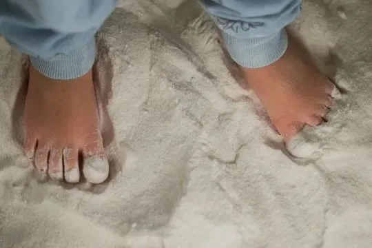 Piedini nudi di bambino nel sale della salt room